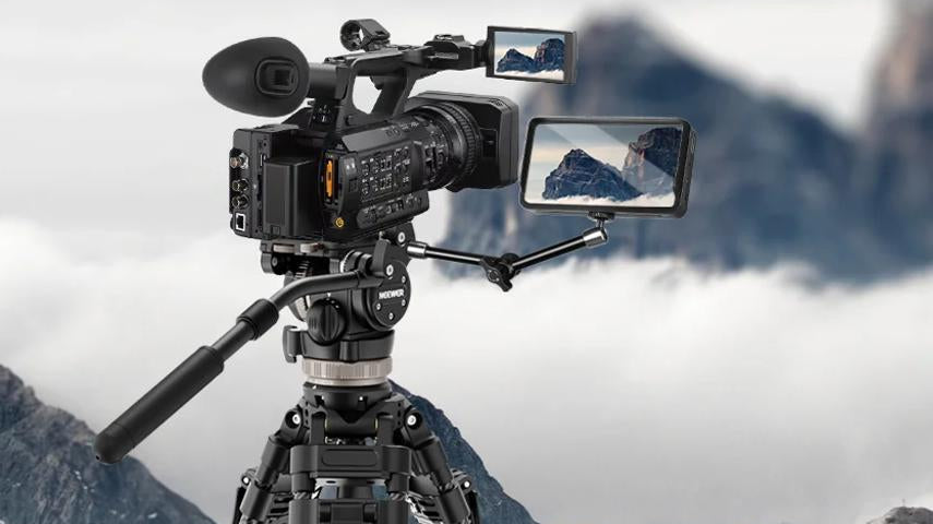 Carbon fiber tripod supports pro video camera in mountains